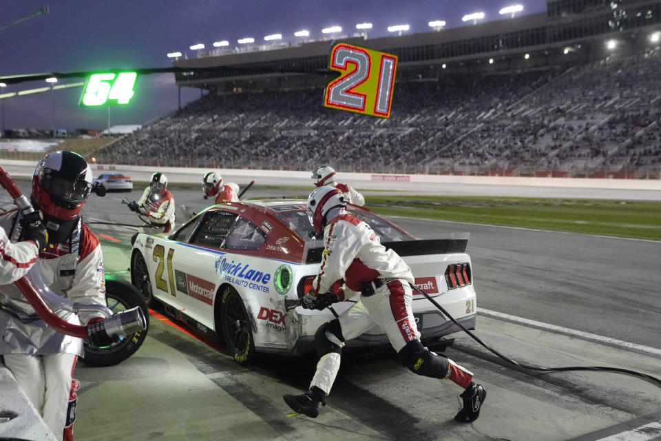 Pit crew memeber work to get Harrison Burton out of the pits during the NASCAR auto race at Atlanta Motor Speedway Sunday, Feb. 25, 2024, in Hampton, Ga. (AP Photo/John Bazemore)