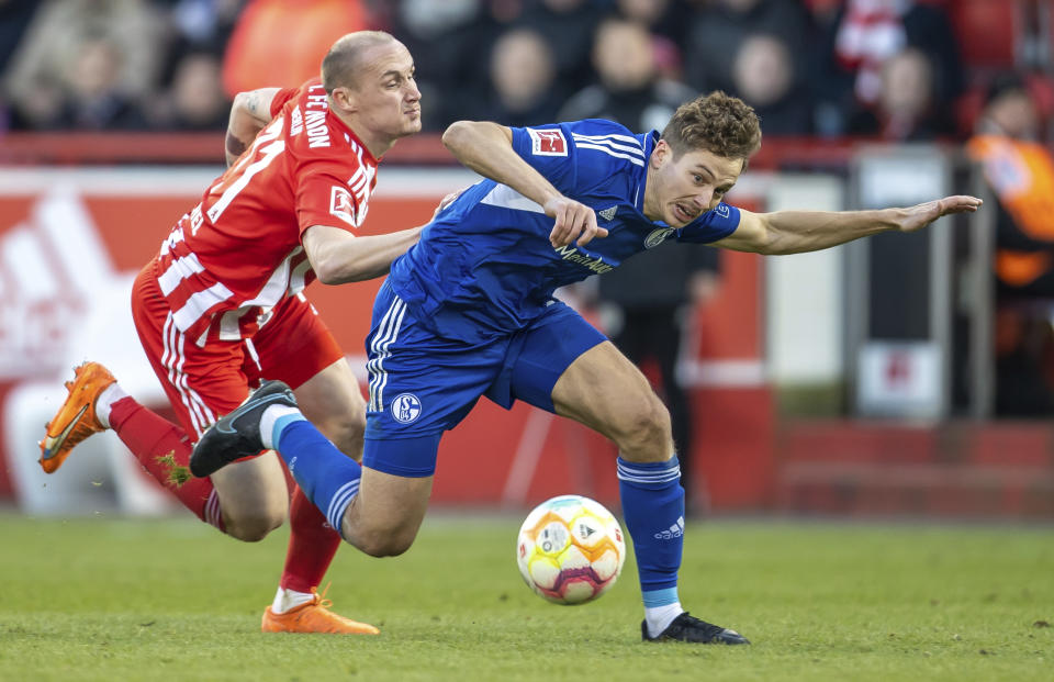 Sven Michel (izquierda) del Union Berlín y Cedric Brunner (derecha) disputan un balón en el partido de la Liga Premier, el domingo 19 de febrero de 2023. (Andreas Gora/dpa vía AP)