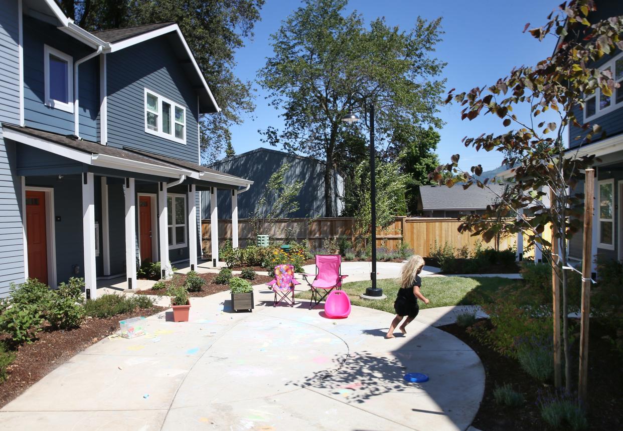 A child plays in a courtyard of the Hayden Bridge Landing housing complex in Springfield overseen by Homes for Good.