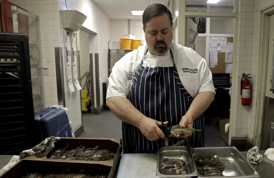 In this photo taken Thursday, June 13, 2013, James Clark, Executive Chef at Carolina Crossroads Restaurant cleans fresh blue crab in his kitchen in Chapel Hill, N.C. Chefs such as Clark go beyond the usual recommendation to eat small, lower-food-chain fish like sardines, and instead delve full force into little-known local catches that many anglers regard as nuisance or “trash” fish. (AP Photo/Gerry Broome)