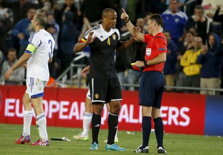 Belgium's Vincent Kompany (C) speaks with the referee Mark Clattenburg after being shown a red card during a Euro 2016 Group B qualifying soccer match against Israel at Teddy Stadium in Jerusalem March 31, 2015. REUTERS/ Ronen Zvulun