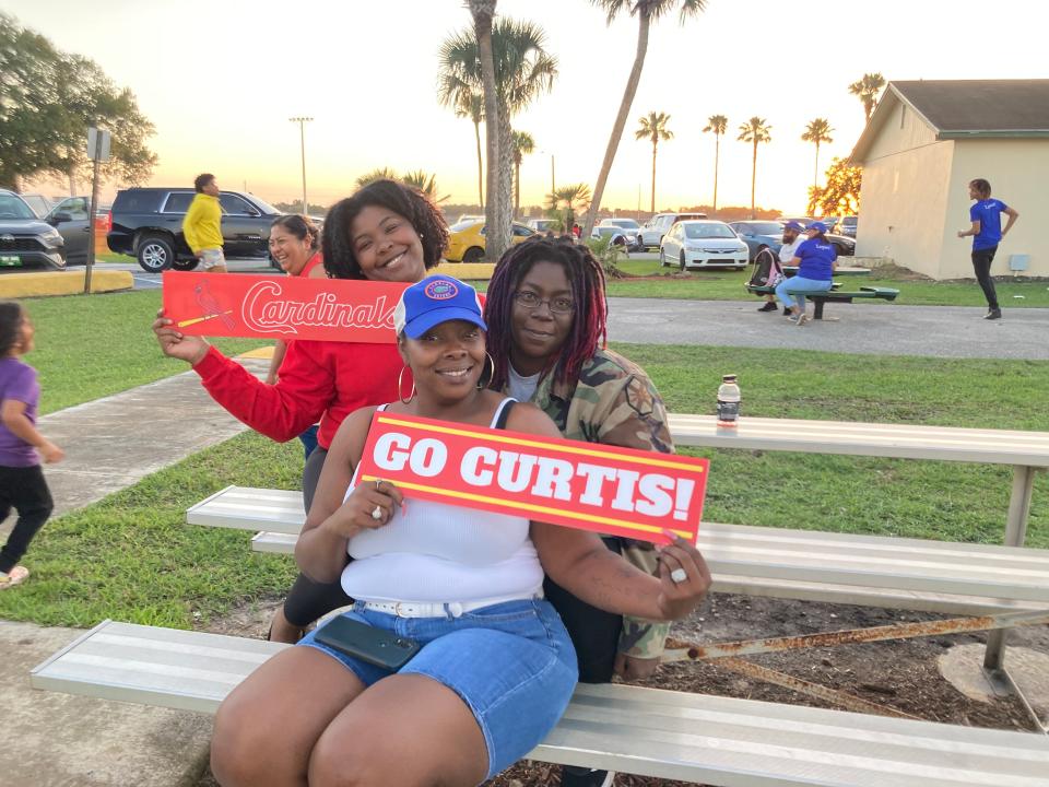 Game attendees hold up custom-made "Go Curtis!" signs sent to the fifth-grader by a fan from California.