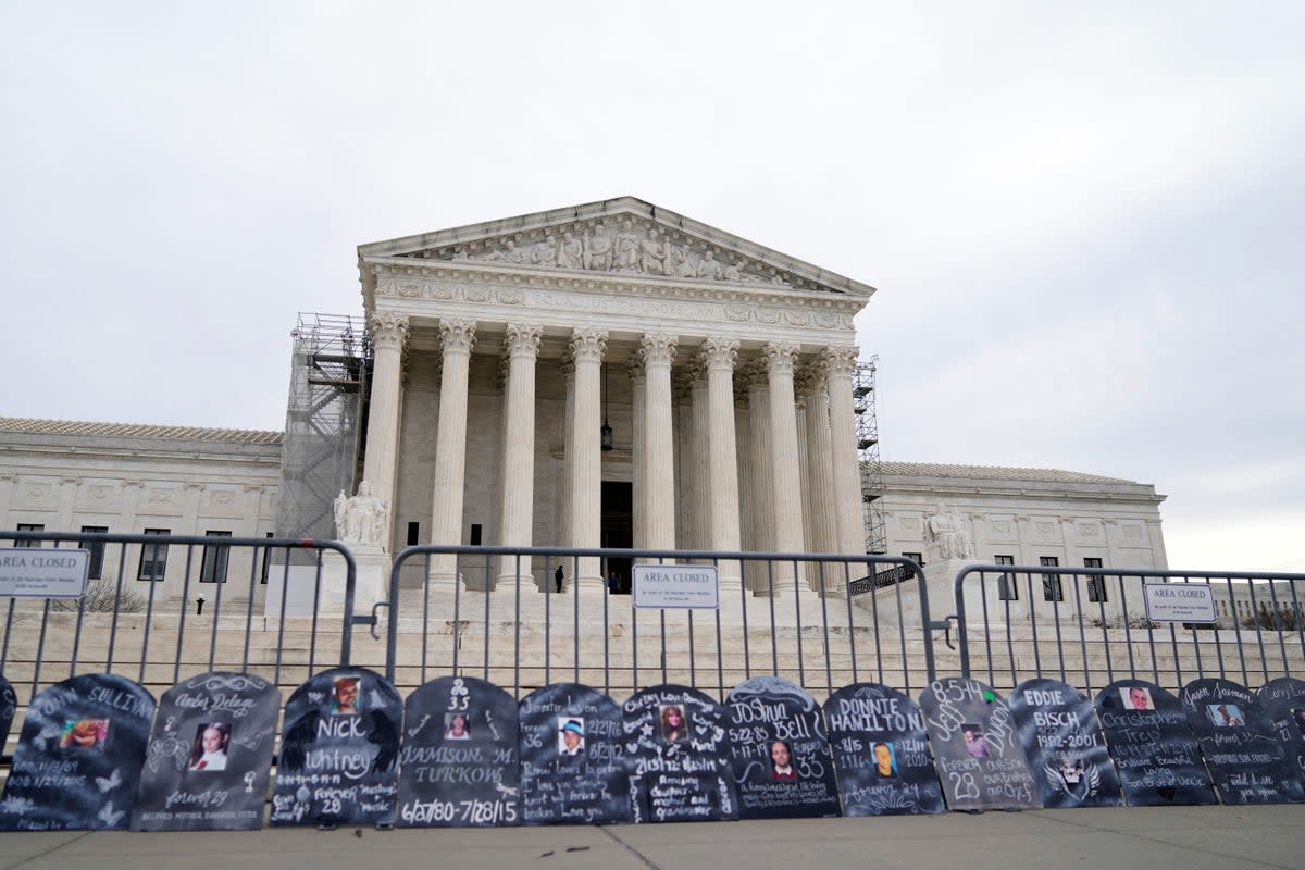 Signs in the shape of grave headstones, with information on people who died from using OxyContin, line a security fence outside the Supreme Court Monday, Dec. 4, 2023 (AP)