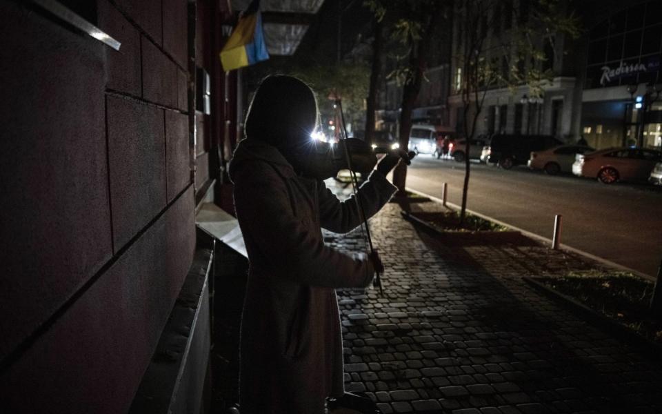 A woman plays the violin on a dark street in Kyiv -  Ed Ram/Getty Images Europe