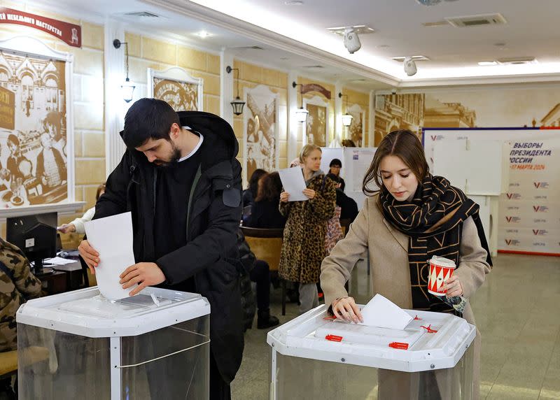 Votantes depositan sus papeletas en un colegio electoral el último día de las elecciones presidenciales en Moscú, Rusia