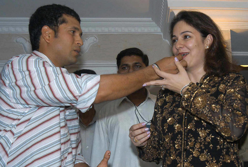 BOMBAY, INDIA: Indian cricketer Sachin Tendulkar (L) gives a piece of cake to his wife Anjali on the eve of his 31st birthday in Bombay, 23 April 2004. Tendulkar had a get-together with family and friends as he will be attending the wedding reception of his colleague Virender Sehwag who recently got married in Delhi. AFP PHOTO (Photo credit should read STR/AFP/Getty Images)