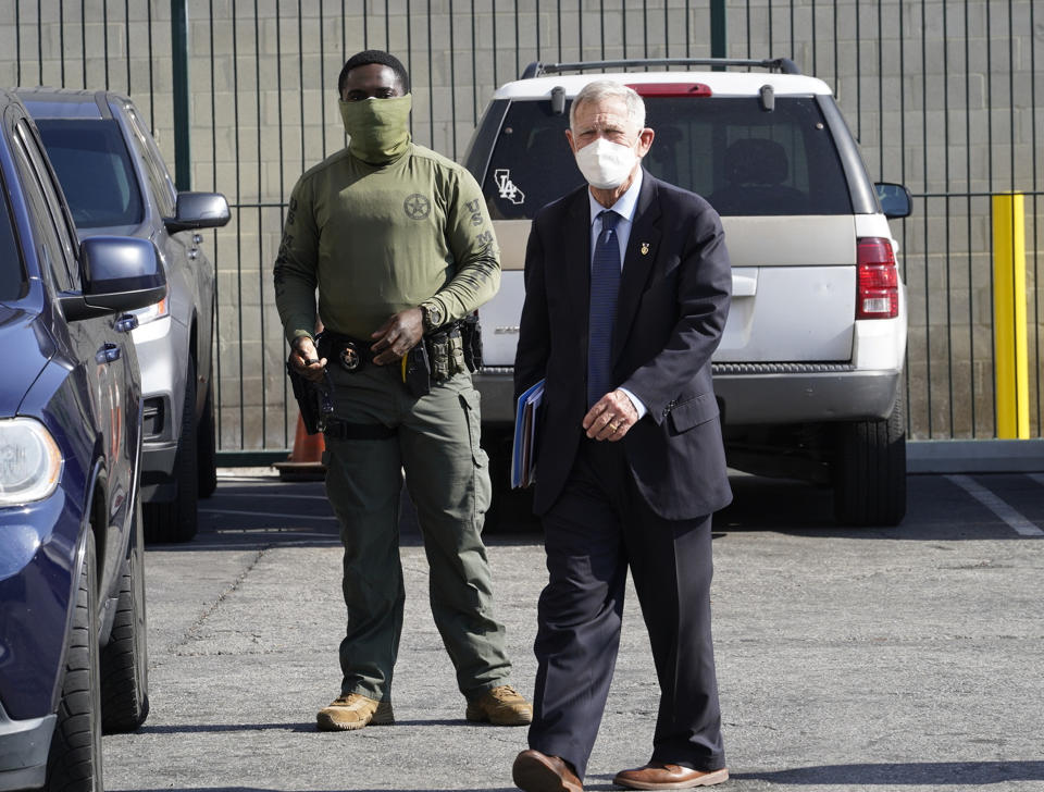 U.S. District Judge David Carter, right, is escorted by U.S. Marshals Service officers after holding a court hearing at the Downtown Women's Center in Los Angeles, Thursday, Feb. 4, 2021. Judge Carter said last week's rainstorm created "extraordinarily harsh" conditions for homeless residents of Los Angeles, prompting him to order city officials to meet with him at a Skid Row shelter to discuss how to address the worsening crisis of people living on the streets. (AP Photo/Damian Dovarganes)