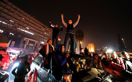 Supporters of Syria's President Bashar al-Assad carry their national flags and gesture as they tour the streets in celebration of what they say is the Syrian army's victory against the rebels in Aleppo, Syria December 12, 2016. REUTERS/Omar Sanadiki