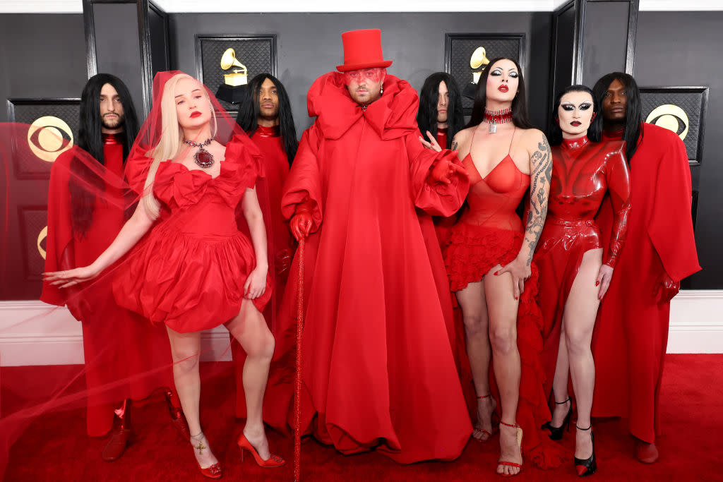 Kim Petras, Sam Smith, Violet Chachki and Gottmik in varying shades of scarlet, Sam Smith in red top hat and robe and red cane.