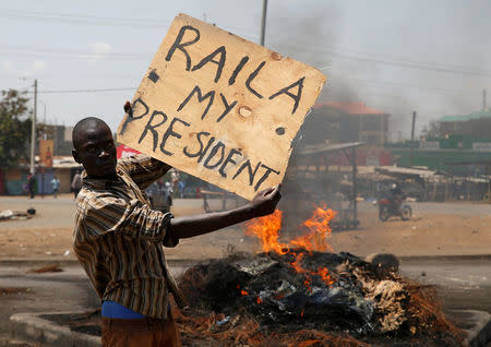 A supporter of Kenyan opposition leader Raila Odinga holds a sign in Kisumu, Kenya August 11, 2017. REUTERS/Baz Ratner