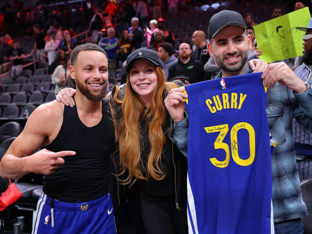 <p>Kevin C. Cox/Getty</p> Curry, Lohan and her husband Bader Shammas at the Golden State Warriors' game in Atlanta on Saturday