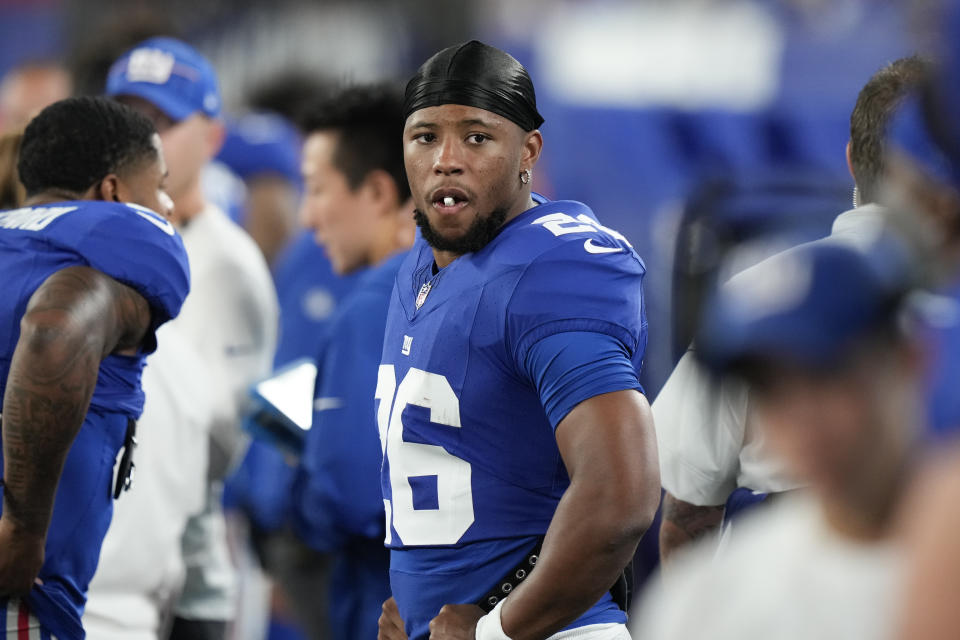 New York Giants' Saquon Barkley watches the game from the sidelines during the second half of an NFL preseason football game against the Carolina Panthers, Friday, Aug. 18, 2023, in East Rutherford, N.J. (AP Photo/Bryan Woolston)