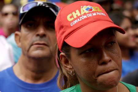 A supporter of Venezuela's President Nicolas Maduro wears a cap that reads, " Chavez, heart of my homeland", as she attends a rally against the application of Organization of American States (OAS) democratic charter, in Caracas, Venezuela June 23, 2016. REUTERS/Marco Bello