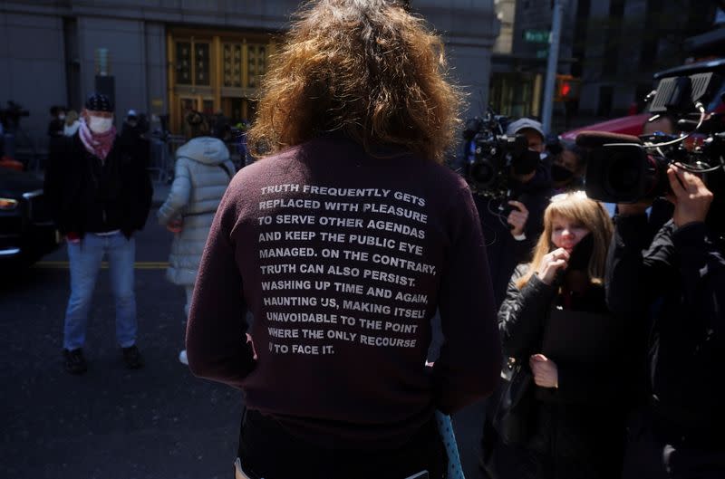 A protester stands outside Manhattan Federal Court ahead of Ghislaine Maxwell's arraignment on a new indictment, in the Manhattan borough of New York City