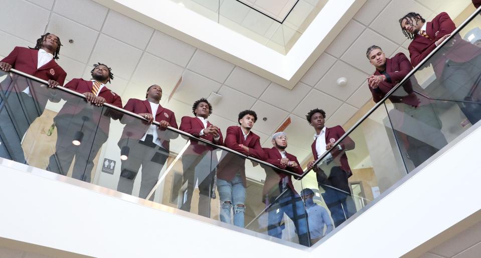 Bethune-Cookman University football players stand on a second floor balcony to watch and listen as head football coach Raymond Woodie speaks, Wednesday Feb. 8, 2023 during a press conference in the Larry R. Handfield Athletic Training Center.