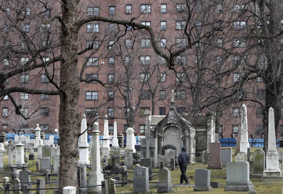 A man walks through Trinity Cemetery in the Washington Heights section of New York, Tuesday, Feb. 21, 2012. (AP Photo/Seth Wenig)