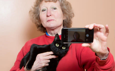 Christine Bayka with one of the 40 black cats she is trynig to rehome - Credit: Anita Maric /SWNS 