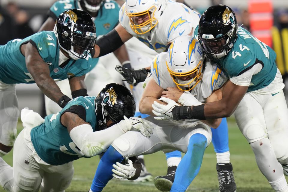 Jacksonville Jaguars linebacker Travon Walker (44) sacks Los Angeles Chargers quarterback Justin Herbert (10) during the second half of an NFL wild-card football game, Saturday, Jan. 14, 2023, in Jacksonville, Fla. (AP Photo/Chris O'Meara)