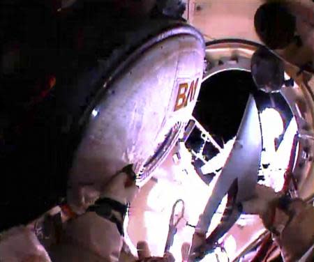 Russian astronaut Oleg Kotov holds an Olympic torch as he prepares to take it on a spacewalk outside the International Space Station in this still image taken from video courtesy of NASA TV, November 9, 2013. REUTERS/NASA TV/Handout via Reuters