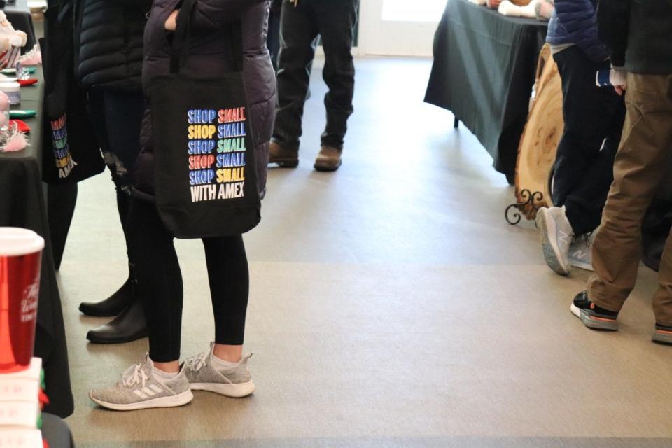 A shopper carries a Shop Small tote bag at the Howard Holiday Market on Saturday, November 26, 2022, at the Howard Park Event Center in South Bend.