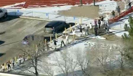 Students from Arapahoe High School evacuate their building in Centennial