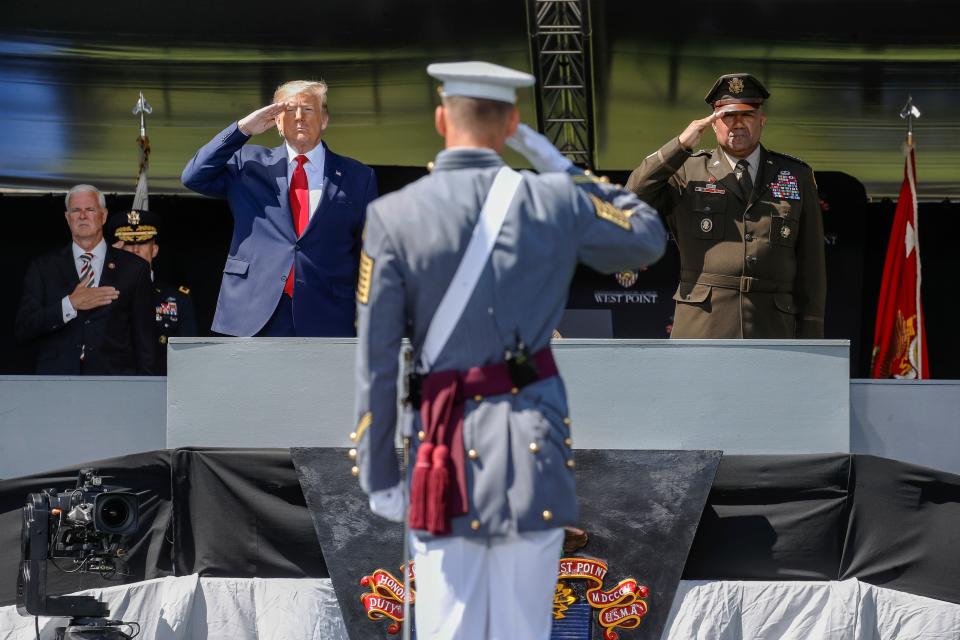 President Donald Trump, left, and United States Military Academy superintendent Darryl A. Williams, right, salute alongside graduating cadets as the national anthem is played during commencement ceremonies on Saturday.