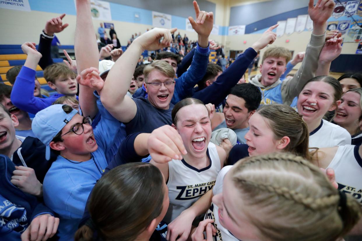 The St. Mary Catholic girls basketball teams celebrates with their fans after beating No. 1-ranked Oostburg on Thursday, 72-69.