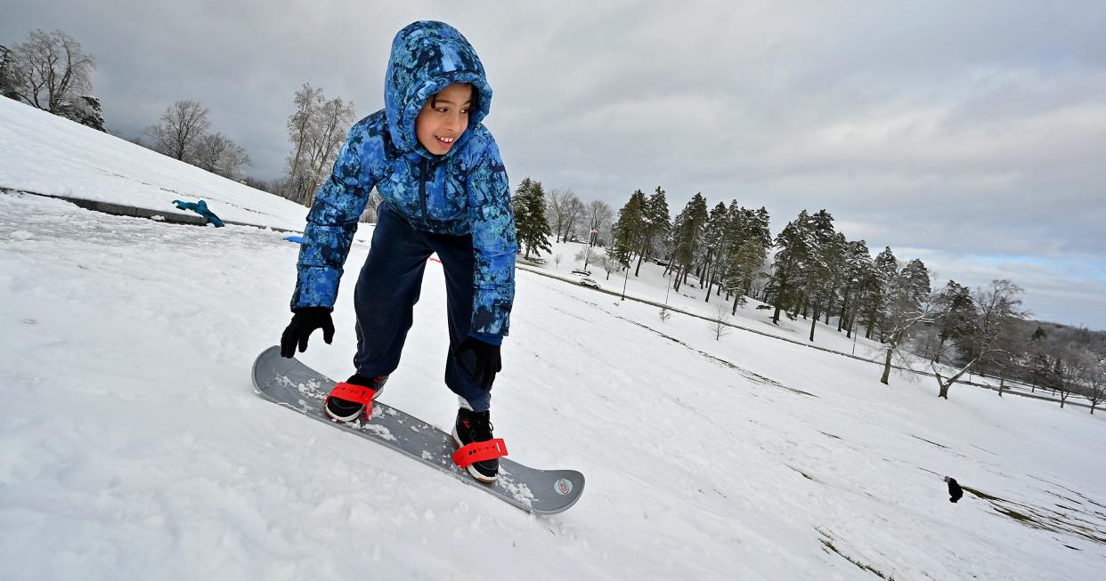 Beginner snowboarder Ricardo DeJesus, 8, of Worcester attempts to make it a few more feet down the hill at Green Hill Park in Worcester on Tuesday.