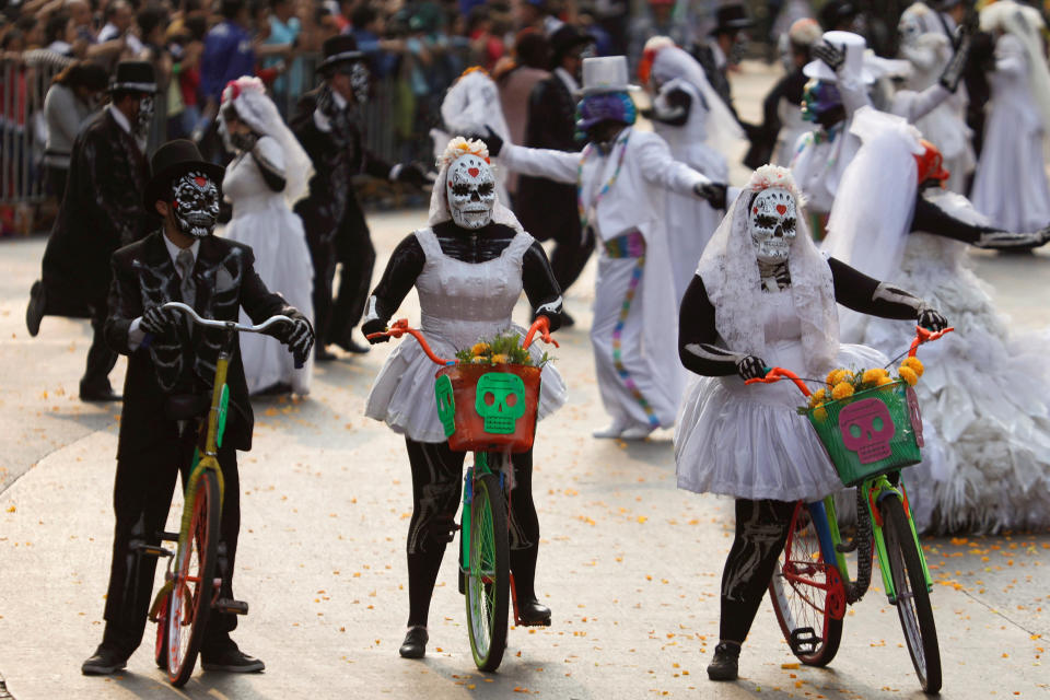 People wearing skull costumes are seen in Mexico City on Saturday.