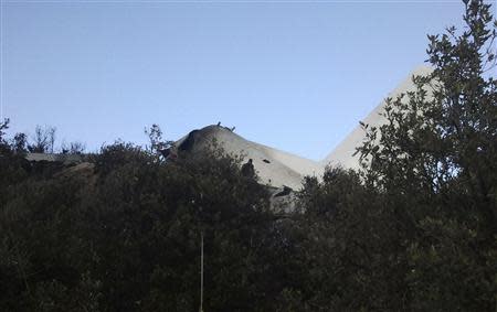 A crashed military plane is seen in Oum El Bouaghi province, about 500 km (311 miles) from the capital Algiers, February 11, 2014. A military transport plane carrying members of the armed forces and their relatives crashed into a mountain in eastern Algeria on Tuesday. The defence ministry said a total of 77 people died in the crash. REUTERS/Stringer