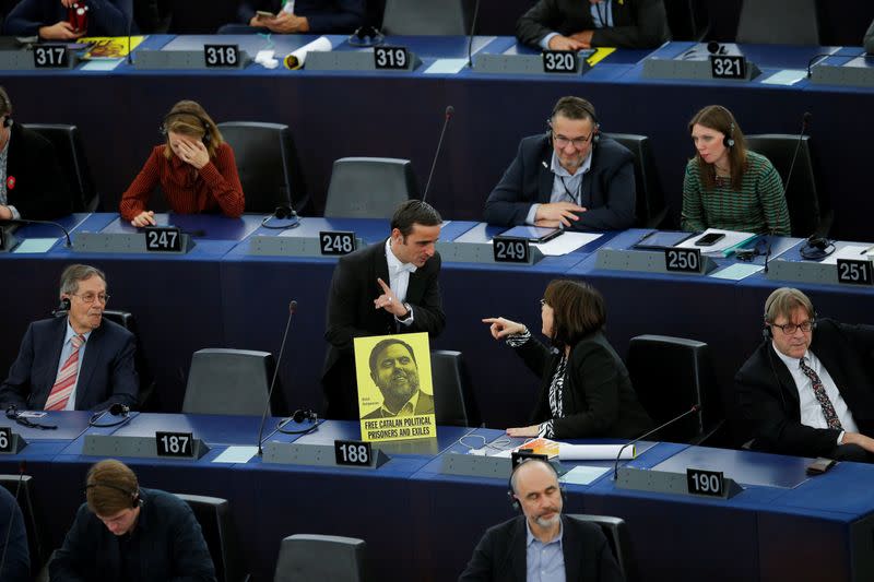 An usher of the parliament removes a banner depicting jailed Catalan leader Oriol Junqueras during a plenary session of the European Parliament in Strasbourg