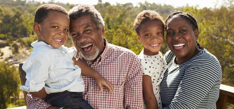 A family with two young kids smiling for the camera