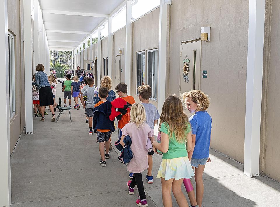 In this file photo, Palm Valley Academy students walk to their classroom in a row of relocatable buildings behind the school.