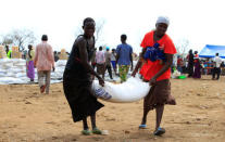 South Sudanese refugees displaced by fighting, carry food rations in Imvepi settlement in Arua district, northern Uganda, April 4, 2017. Picture taken April 4, 2017. REUTERS/James Akena