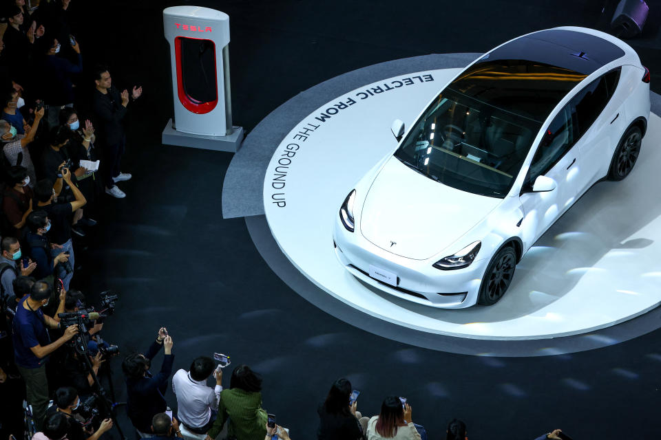 Members of media and guests surround the Tesla Model Y during Thailand Tesla's official launch event in Bangkok, Thailand, December 7, 2022. REUTERS/Athit Perawongmetha