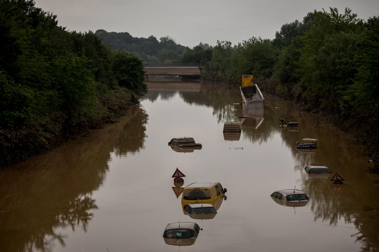 Un miembro del personal de auxilio inspecciona un camión que había sido levantado sobre un auto por las inundaciones cerca de Erfstadt, Alemania, el 17 de julio de 2021. (Gordon Welters / The New York Times)