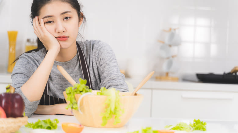 bored cook preparing salad