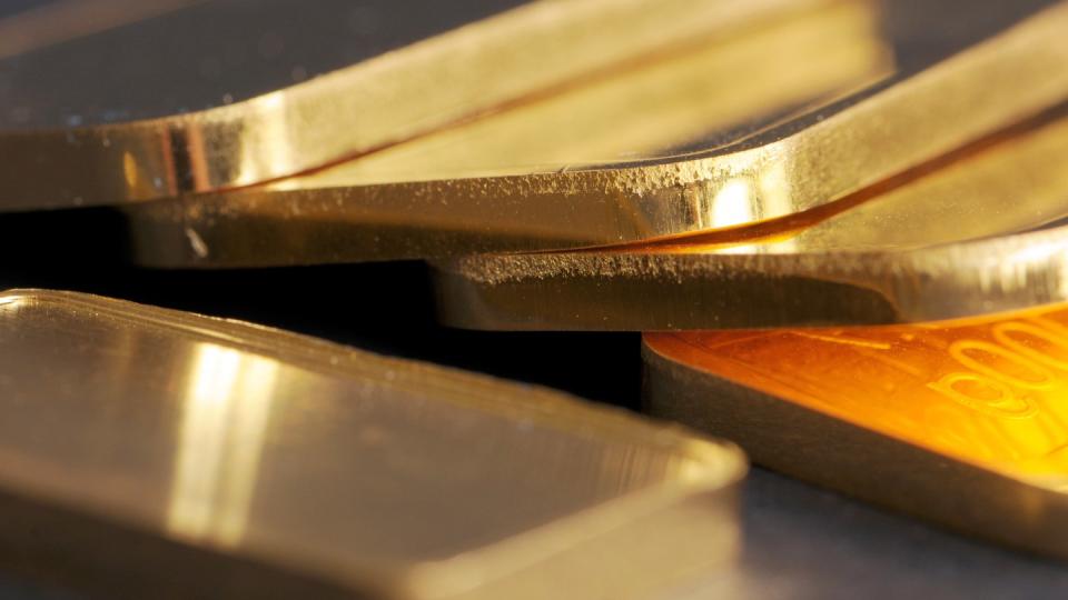 Goldbarren mit 100 Gramm Gewicht liegen auf einem Tisch.