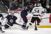 Winnipeg Jets goaltender Connor Hellebuyck, left, gives up a goal on a shot from Los Angeles Kings right wing Viktor Arvidsson, not seen, during the first period of an NHL hockey game Saturday, March 25, 2023, in Los Angeles. (AP Photo/Marcio Jose Sanchez)