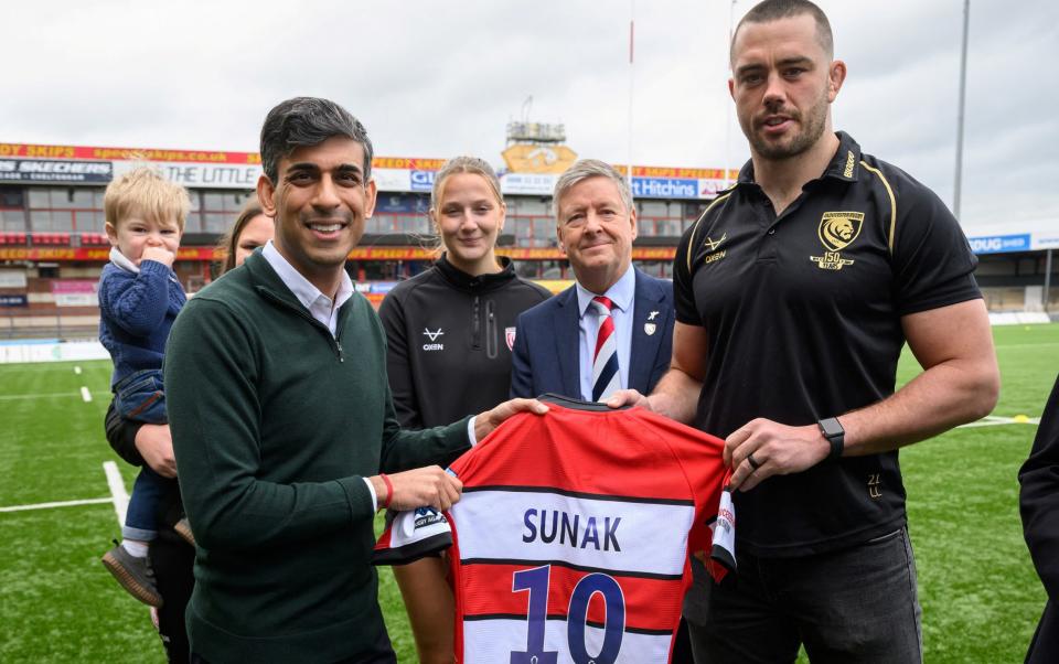 Gloucester Rugby Club Captain Lewis Ludlow presents Britain's Prime Minister Rishi Sunak with a number 10 team shirt during a visit to Gloucester Rugby Club, in Gloucester, Britain