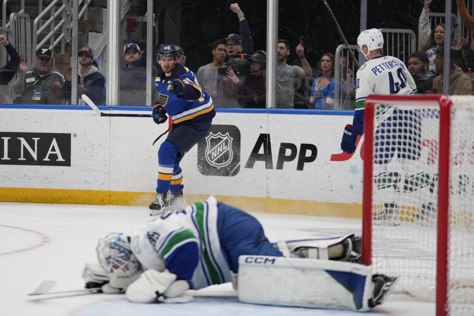 St. Louis Blues' Pavel Buchnevich, top, celebrates after scoring past Vancouver Canucks goaltender Thatcher Demko, bottom as Canucks' Elias Pettersson (40) watches during the second period of an NHL hockey game Tuesday, March 28, 2023, in St. Louis. (AP Photo/Jeff Roberson)