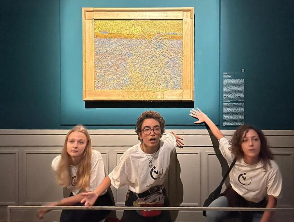 This photo obtained from Italian news agency Ansa on November 4, 2022 shows Climate activists from Last Generation posing by "The Sower", an 1888 painting by Dutch artist Vincent Van Gogh, after they threw pea soup at it on November 4, as it was on show at Rome's Palazzo Bonaparte.