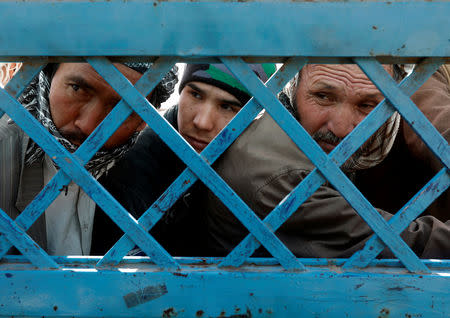 Afghan men line up to cast their votes during a parliamentary election at a polling station in Kabul, Afghanistan October 21, 2018. REUTERS/Omar Sobhani