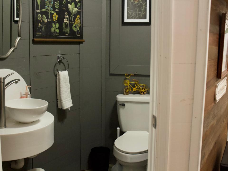 Insider view of a bathroom with toilet, sink and gray walls