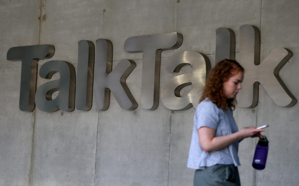 A woman views her phone as she passes a branded logo outside the Talktalk headquarters in London, Britain May 10, 2017. REUTERS/Neil Hall