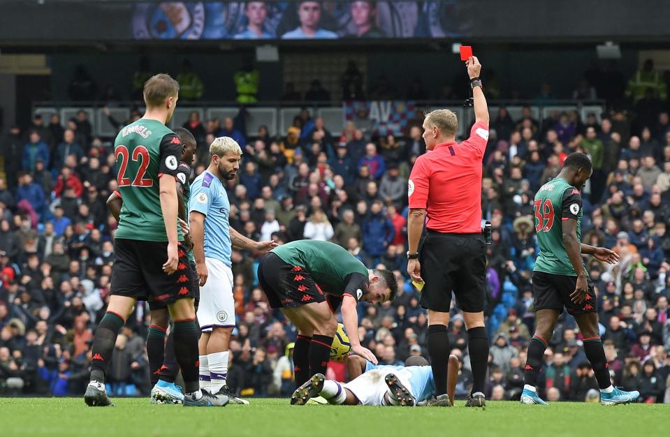 Referee Graham Scott shows the a red card to send off Manchester City's Brazilian midfielder Fernandinho (bottom) during the English Premier League football match between Manchester City and Aston Villa at the Etihad Stadium in Manchester, north west England, on October 26, 2019. - Manchester City won the game 3-0. (Photo by Paul ELLIS / AFP) / RESTRICTED TO EDITORIAL USE. No use with unauthorized audio, video, data, fixture lists, club/league logos or 'live' services. Online in-match use limited to 120 images. An additional 40 images may be used in extra time. No video emulation. Social media in-match use limited to 120 images. An additional 40 images may be used in extra time. No use in betting publications, games or single club/league/player publications. /  (Photo by PAUL ELLIS/AFP via Getty Images)