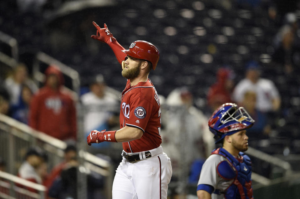 Washington Nationals' Bryce Harper celebrates his two-run home run as Chicago Cubs catcher Victor Caratini waits near the plate during the seventh inning of the second baseball game of a doubleheader, Saturday, Sept. 8, 2018, in Washington. (AP Photo/Nick Wass)