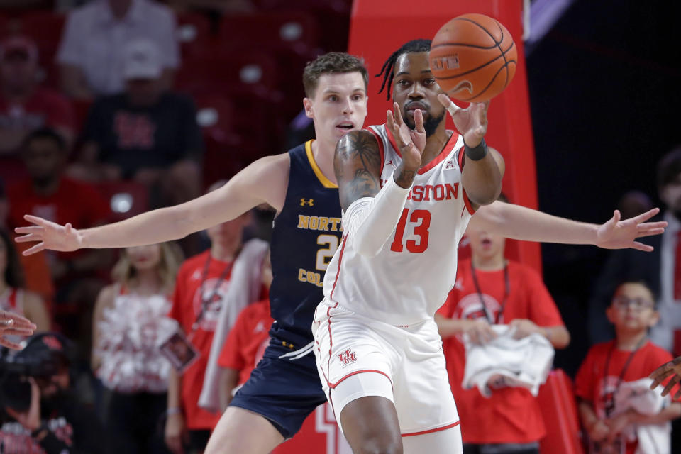 Houston forward J'Wan Roberts (13) passes the ball in front of Northern Colorado forward Riley Abercrombie, left, during the first half of an NCAA college basketball game Monday, Nov. 7, 2022, in Houston. (AP Photo/Michael Wyke)