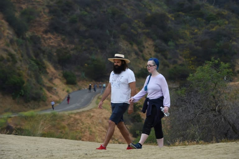 Chuck McCarthy chats with his client Anie Dee (R) as they walk in the Hollywood Hills in Runyon Canyon Park