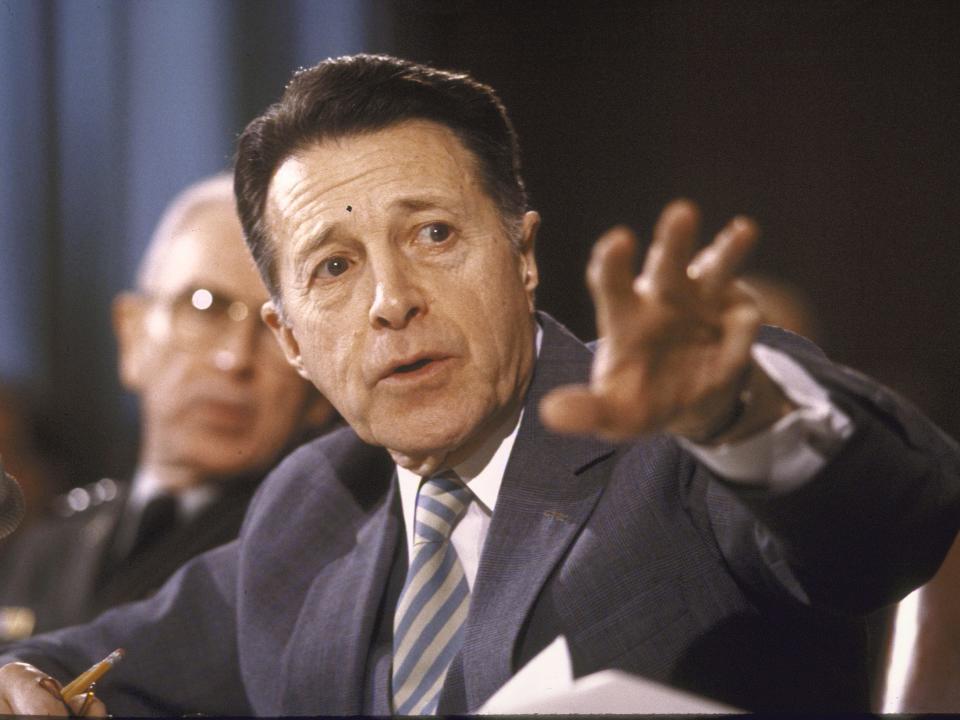 Defense Secretary Caspar W. Weinberger outsretches his arm during a Senate Armed Services Committee hearing in 1985.